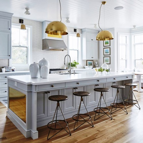 Full view of kitchen with warm hardwood flooring, clean white walls and brass accents