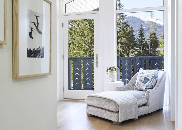 Chaise lounge in front of glass doors overlooking mountainous landscape