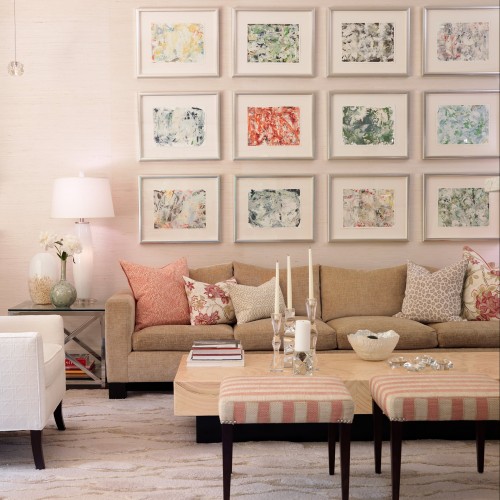 Numerous colourful pictures hang from the wall above a comfortable couch