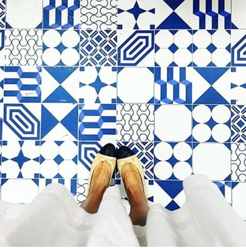 Looking down at blue and white geometric tiles.