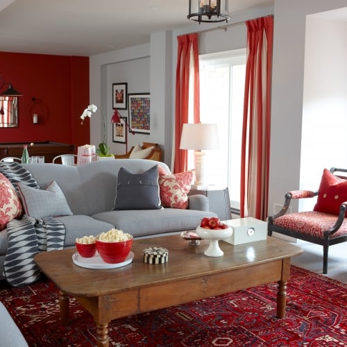 Front view of rec room showing grey sofa with cozy pillows and big red rug